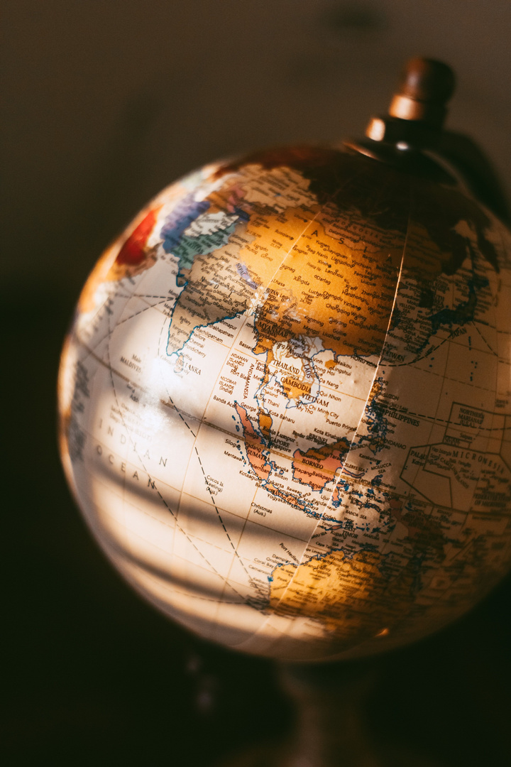 Close-up of a glass world globe lit in warm light
