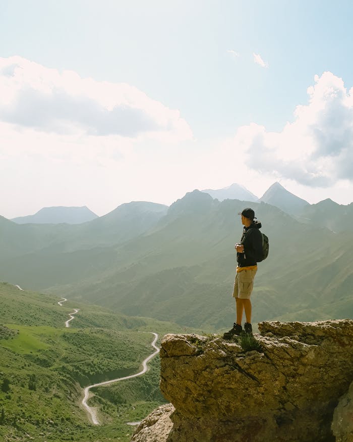 A lone hiker overlooks a vast mountain landscape, a moment of reflection that ministry travel can provide pastors.